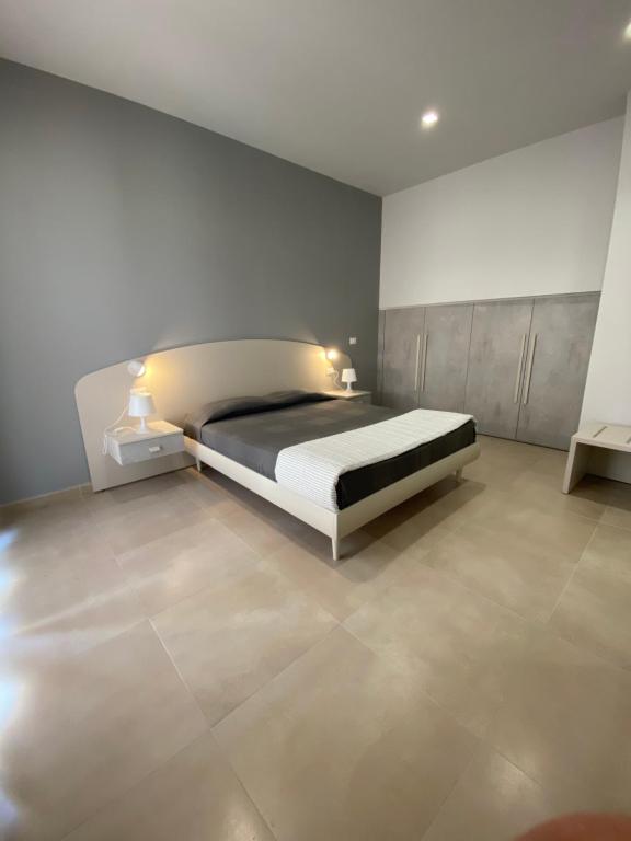 Plus welcome Apartments Panarea - Stromboli في جيويوسا ماريا: غرفة نوم فيها سرير وليلتين تقف فيها