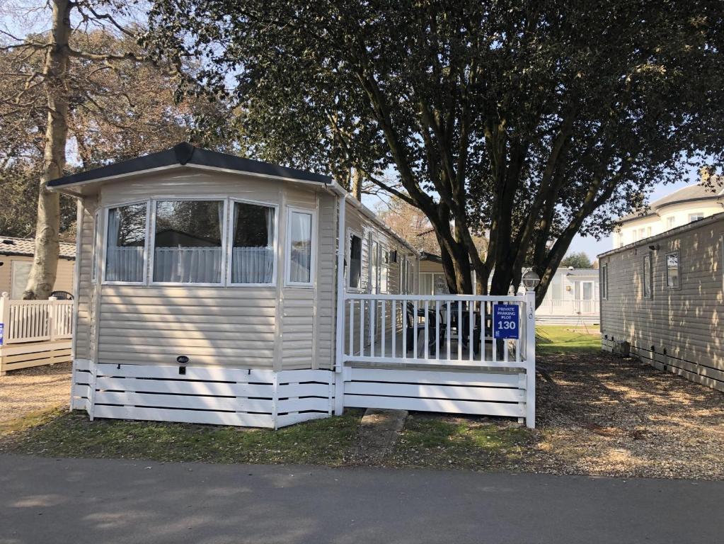 a white house with a gate and a fence at Mudeford Beach Lodge in Mudeford