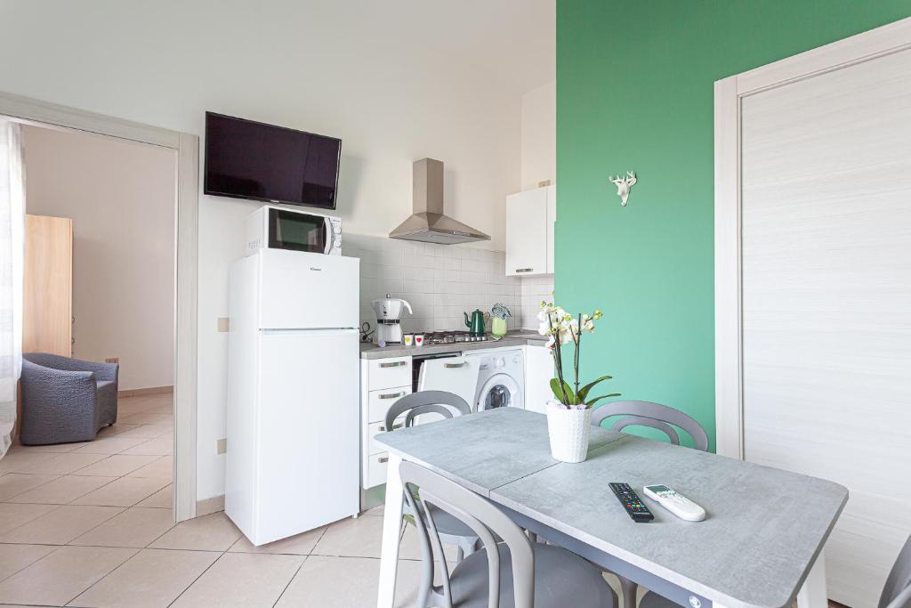 una cucina con tavolo e frigorifero bianco di Nicola House La Pineta a Cervia