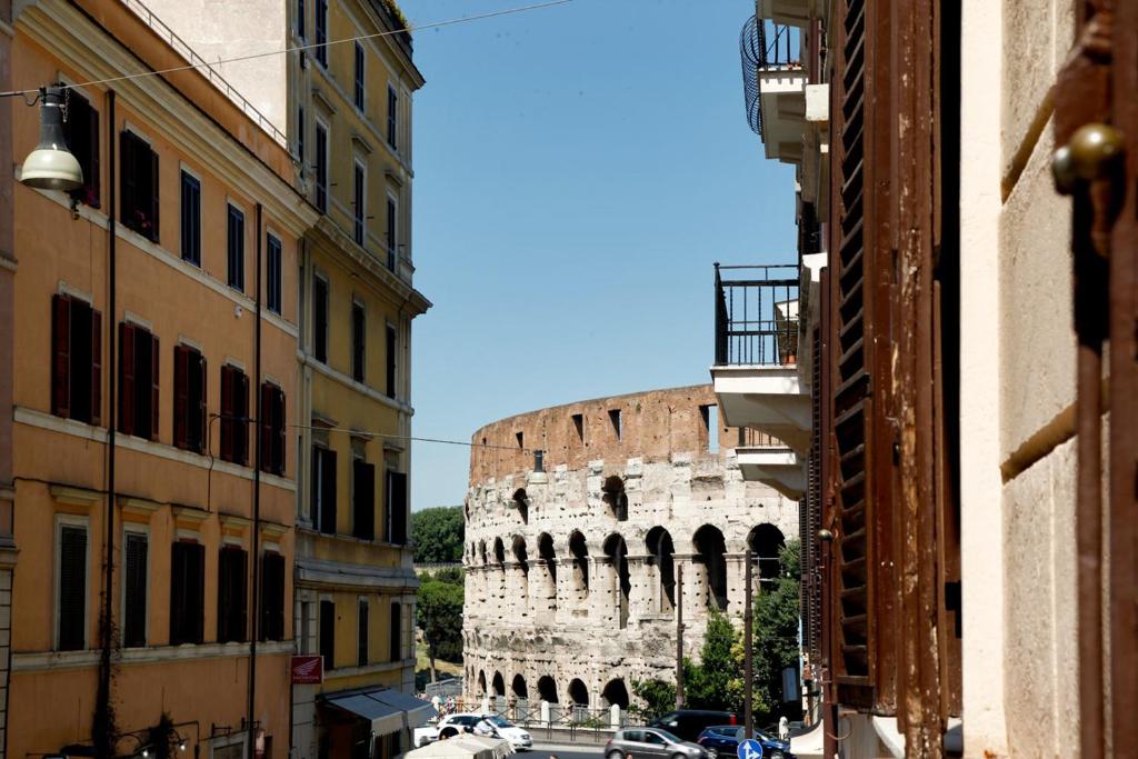 a view of the coliseum from a city street at Colosseo Apartments and Rooms - Rome City Centre in Rome