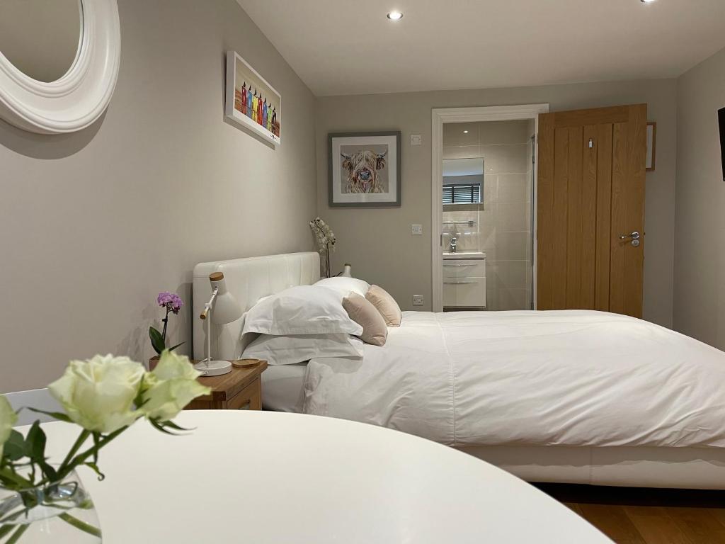 1 dormitorio con 2 camas con sábanas blancas en No 12 Furze Croft, en St Ives