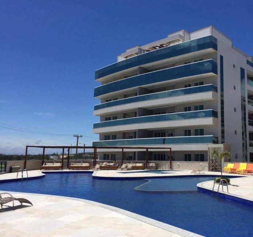 a large building with a swimming pool in front of a building at Le Bon Vivant Arraial beach in Arraial do Cabo
