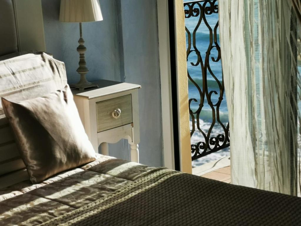アラッシオにあるB&B DaGiueliのベッドルーム1室(ベッド1台付)、バルコニーへのドアが備わります。