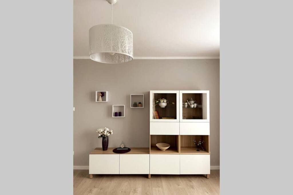 a white cabinet in a white room with a lamp at Modern apartment in Tarnow in Tarnów