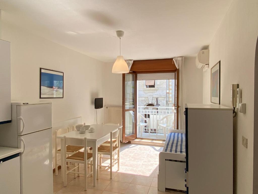 a kitchen and dining room with a table and a refrigerator at Europa Unita Apartment in Grado
