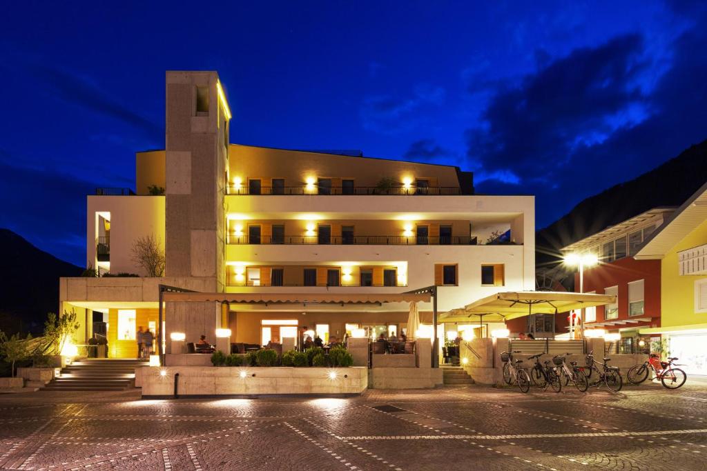 un edificio con bicicletas estacionadas frente a él por la noche en Kleinkunsthotel, en Naturno