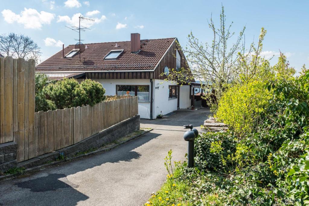 a house with a wooden fence and a driveway at Ferienwohnung Munding in Überlingen