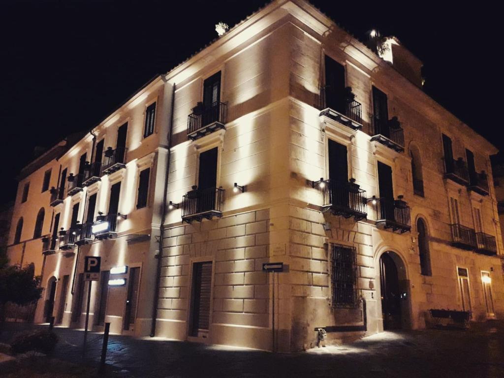 een groot bakstenen gebouw met ramen in de nacht bij La Locanda del Baffo in Capua