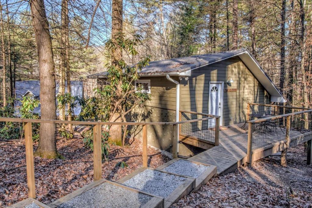 een kleine hut in het bos met een houten terras bij Pisgah Hillside Haven in Pisgah Forest