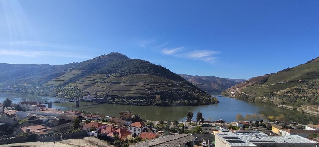 a view of a river with a town and a mountain at Alojamento Dos Santos - Pinhão in Pinhão