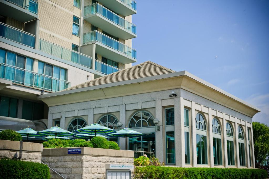 un edificio con sombrillas frente a un edificio en The Waterside Inn, en Mississauga