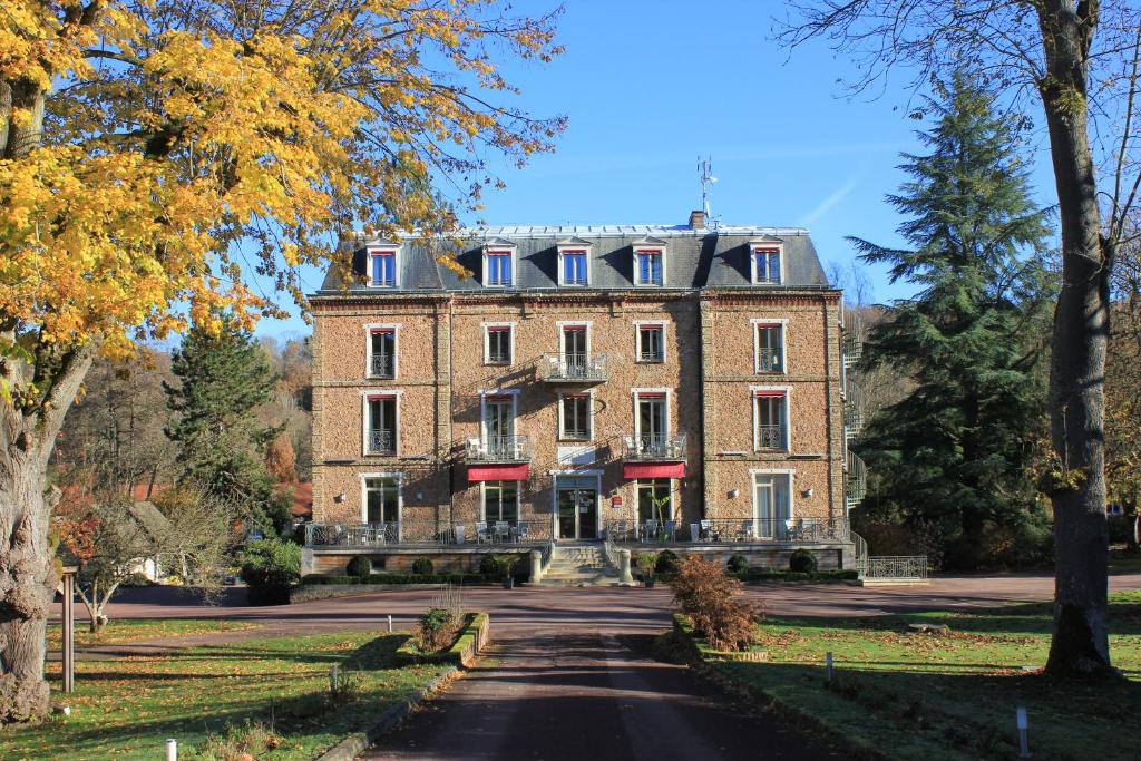 um grande edifício de tijolos numa estrada em Logis Hôtel & Restaurant - Le Manoir de Sauvegrain em Saint-Lambert