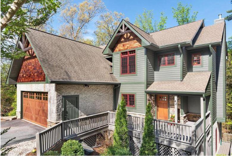 a green house with a brown roof at Hidden Creek Lodge in Asheville