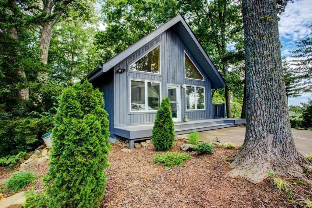 ein blaues winziges Haus im Wald in der Unterkunft Sunrise Cottage in Asheville