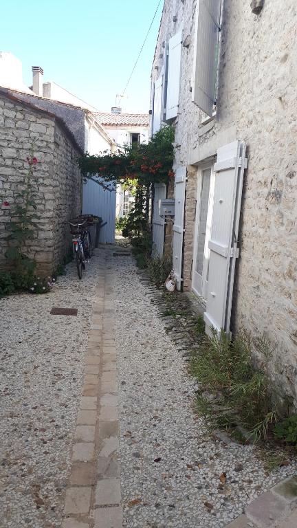 Une allée avec un vélo garé à côté d'un bâtiment dans l'établissement grange4, à Sainte-Marie de Ré