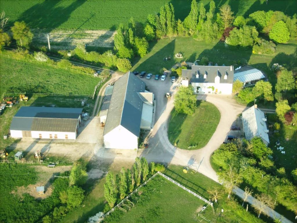 - une vue aérienne sur une grande maison avec une église dans l'établissement Gîte de la Ferme Florale Ponoie, à Chezal-Benoît