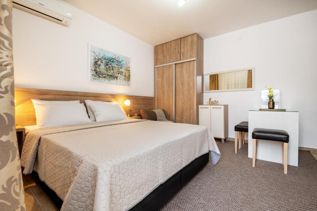 um quarto de hotel com uma cama e uma secretária em Apartmani IVA em Neum