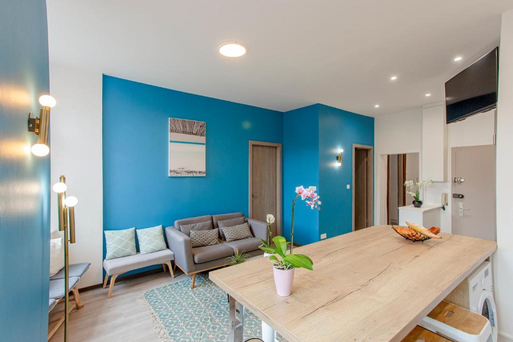 - un salon bleu avec une table et un canapé dans l'établissement Chez Marc - Centre Historique - 2 salles d'eau - Wifi - tout confort - NOUVEAU, à Colmar