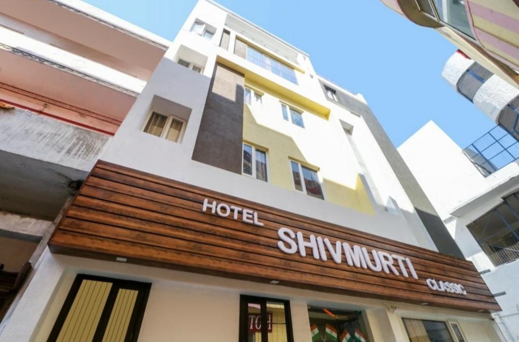 a hotel with a sign on the front of it at Hotel ShivMurti Classic in Haridwār