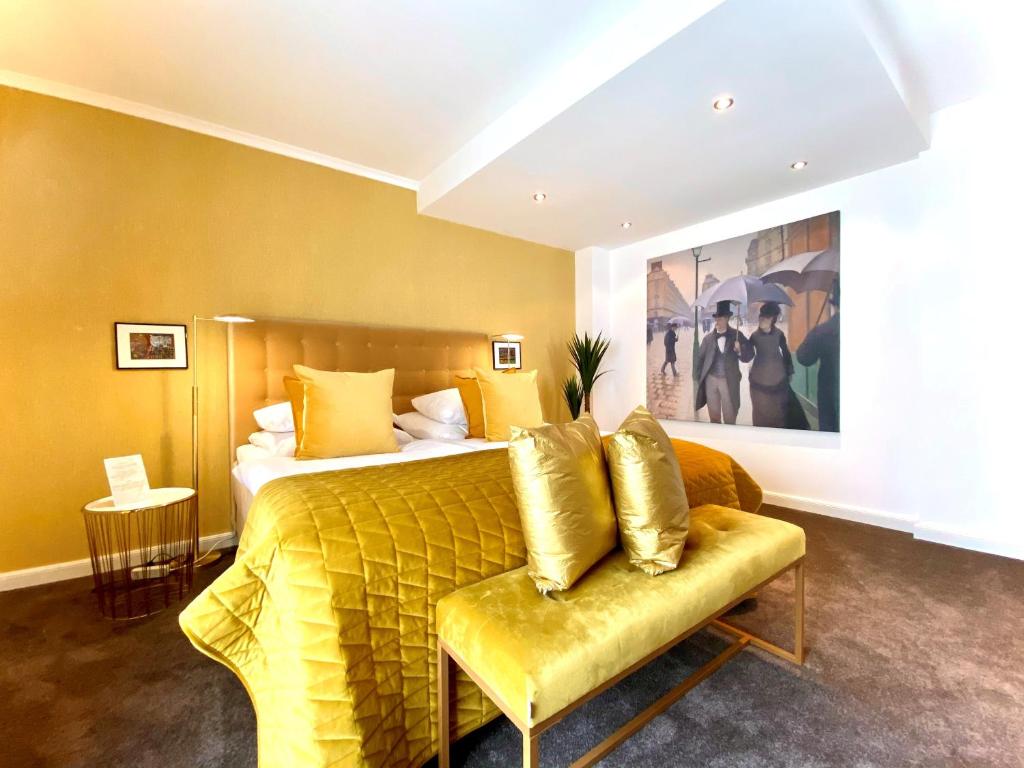 une chambre d'hôtel avec un lit et un canapé jaune dans l'établissement Parkhotel Bielefeld, à Bielefeld