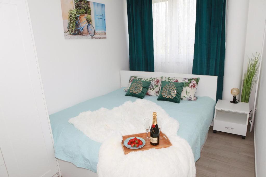 a bedroom with a bed with a tray with a bottle of champagne at Apartman Lucija in Karlovac