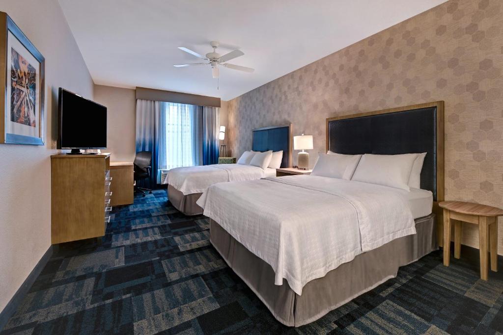 a hotel room with two beds and a flat screen tv at Homewood Suites By Hilton Austin/Cedar Park-Lakeline, Tx in Austin