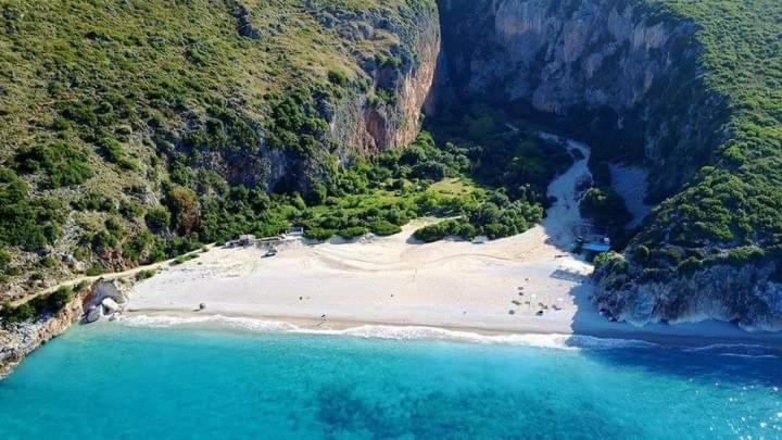 an aerial view of a beach with blue water at Gjipe Eco Campground in Vuno