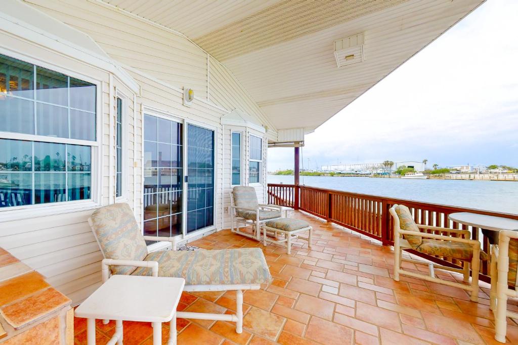 een veranda met stoelen en een tafel en uitzicht op het water bij Long Island Village Unit 349 Sand Dollar Dr in Port Isabel
