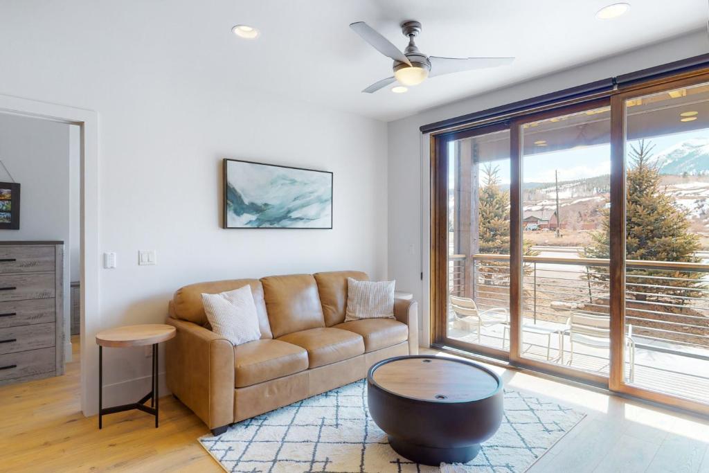 a living room with a couch and a large window at Blue River Flats Condos in Silverthorne