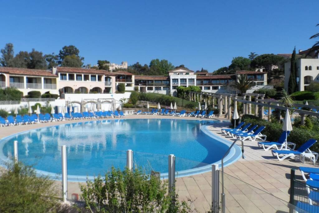 una gran piscina con sillas y sillas azules en Les Parcs de Grimaud, en Grimaud