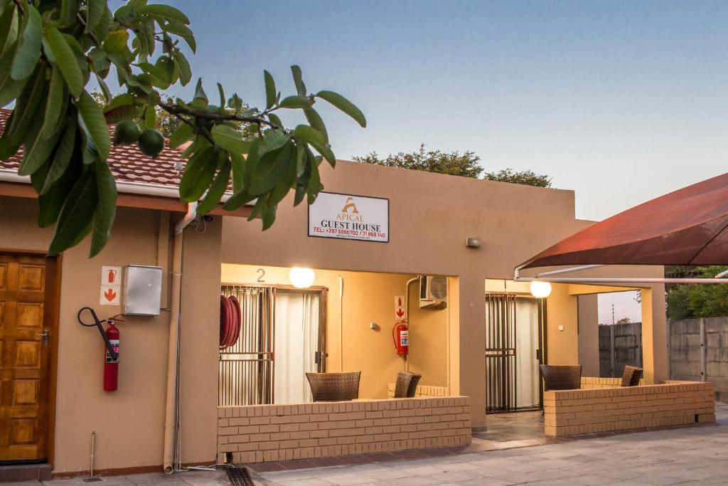 un restaurant avec un panneau sur le côté d'un bâtiment dans l'établissement APICAL GUESTHOUSE, à Maun