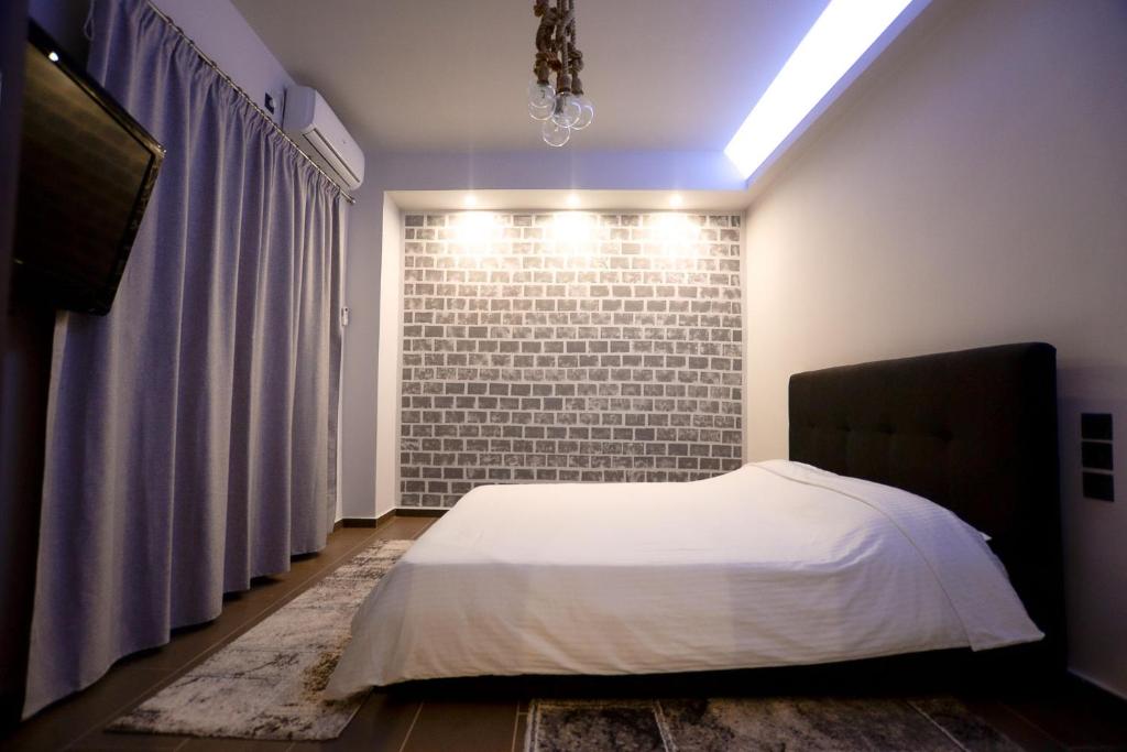 sypialnia z łóżkiem i ceglaną ścianą w obiekcie CENTRO PATRAS w mieście Patras