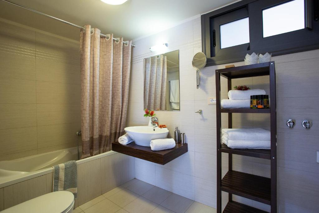 łazienka z umywalką, toaletą i wanną w obiekcie Elounda Olea Villas And Apartments w Elundzie