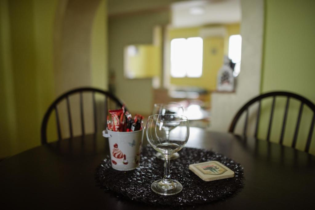 a table with a wine glass and a container of candy at Apartment Slađana in Subotica