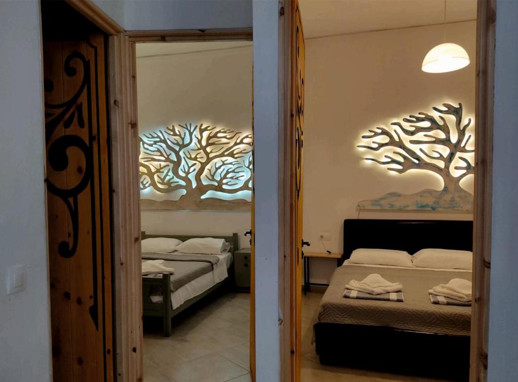 a bedroom with two beds with trees on the wall at Despina garden view in Agia Galini