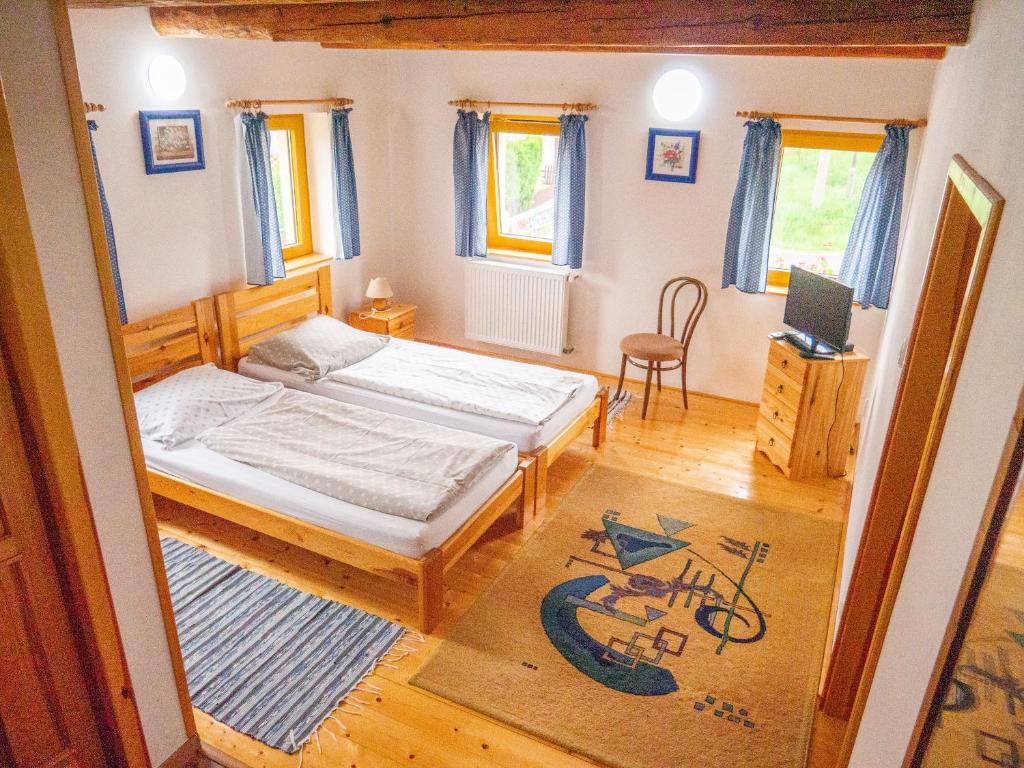 a small bedroom with two beds and a chair at Penzion U Cempu in Kunratice