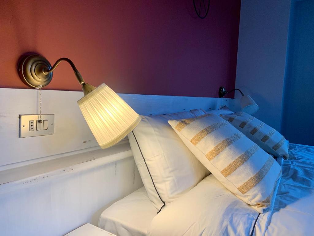 a bed that has a lamp on top of it at Casa di Franz in Vigo di Fassa