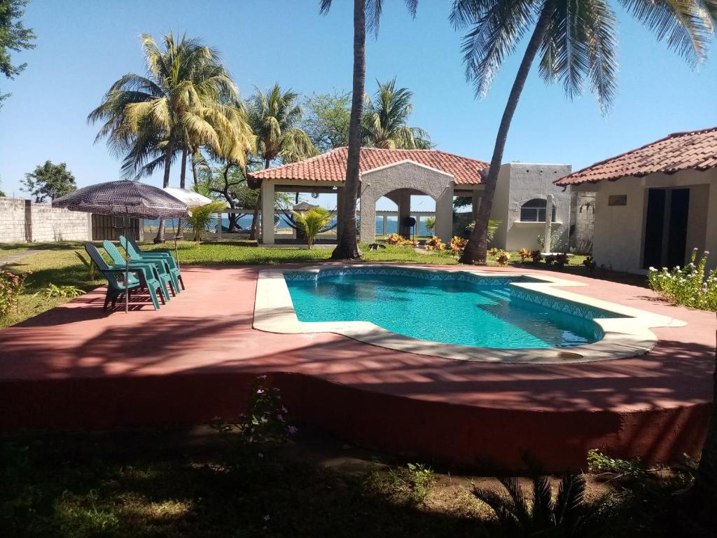 El Tamarindo的住宿－La Ceja Beach House，棕榈树庭院内的游泳池