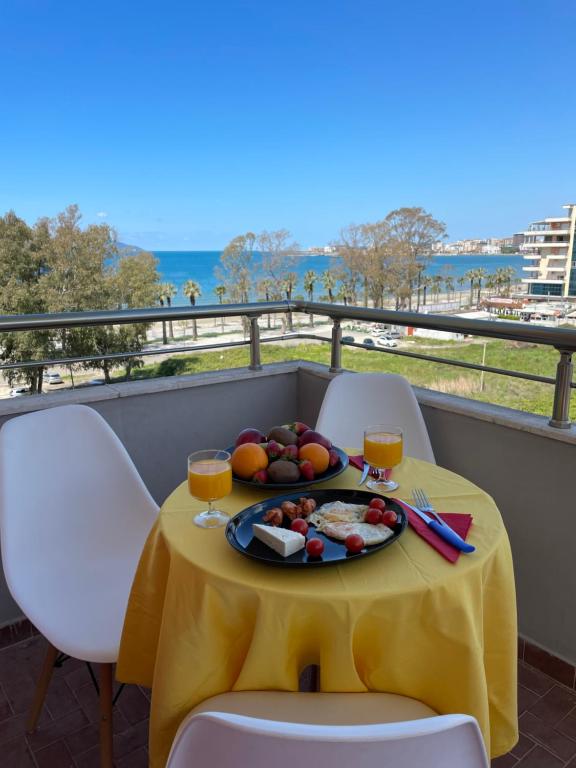 uma mesa com um prato de comida numa varanda em FAMILY SUITE RESIDENCE em Vlorë