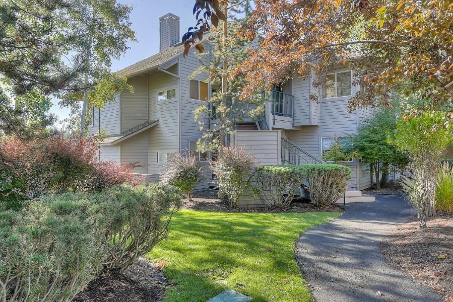 a house with a yard with grass and trees at River Ridge 416B condo in Bend