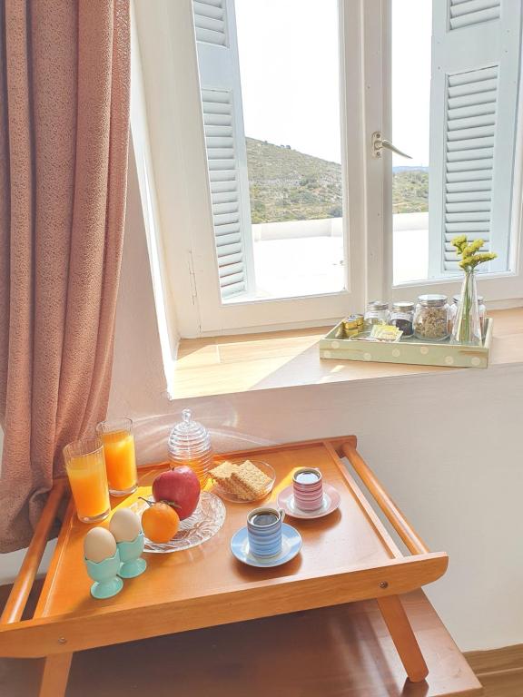 - un plateau de petit-déjeuner sur une table devant une fenêtre dans l'établissement Vira Señor House, à Triovasálos