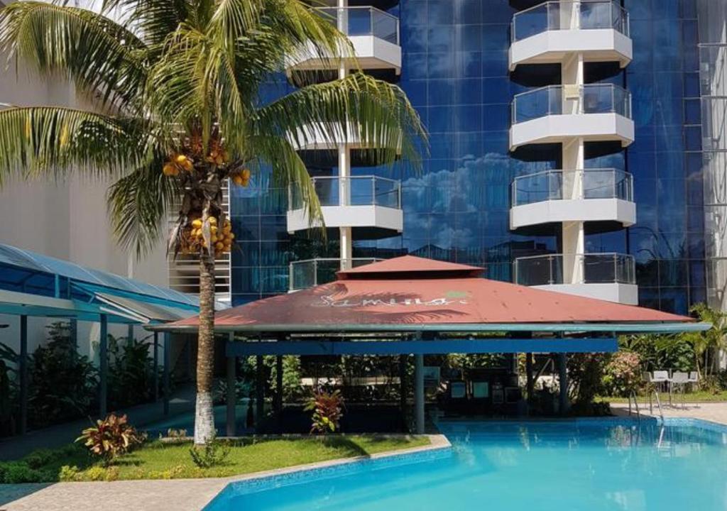 um hotel com uma palmeira e um edifício em Samiria Jungle Hotel em Iquitos