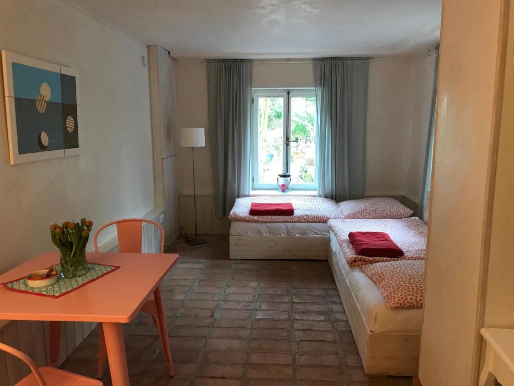 a room with two beds and a table and a window at Der Birkenhof - Birch Court in Düsseldorf
