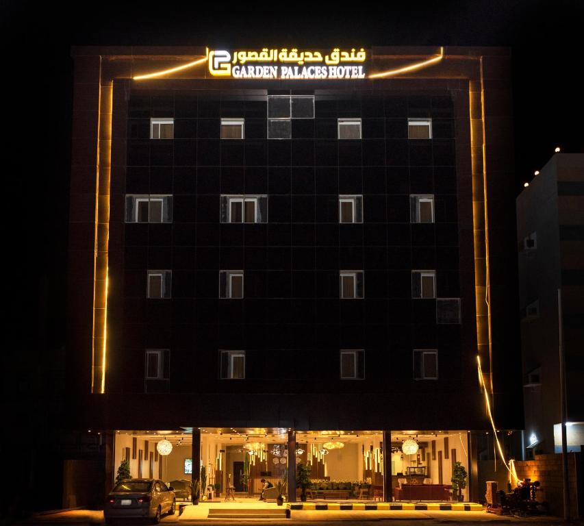 a building with a sign on top of it at night at فندق حديقة القصور in Şāmitah