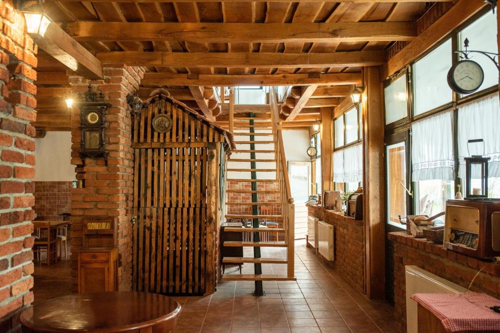 une chambre avec un escalier, une table et une horloge dans l'établissement Kuća za odmor Vallirea, à Kaptol
