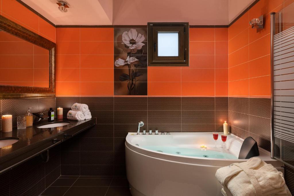 pomarańczowa łazienka z wanną i umywalką w obiekcie Costa Costa Villa - Luxury villa w Kolymbii