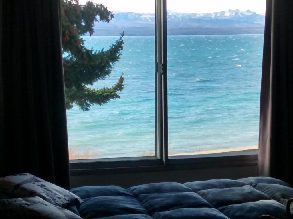 een kamer met een raam met uitzicht op de oceaan bij Departamento Costanera Bariloche in Bariloche