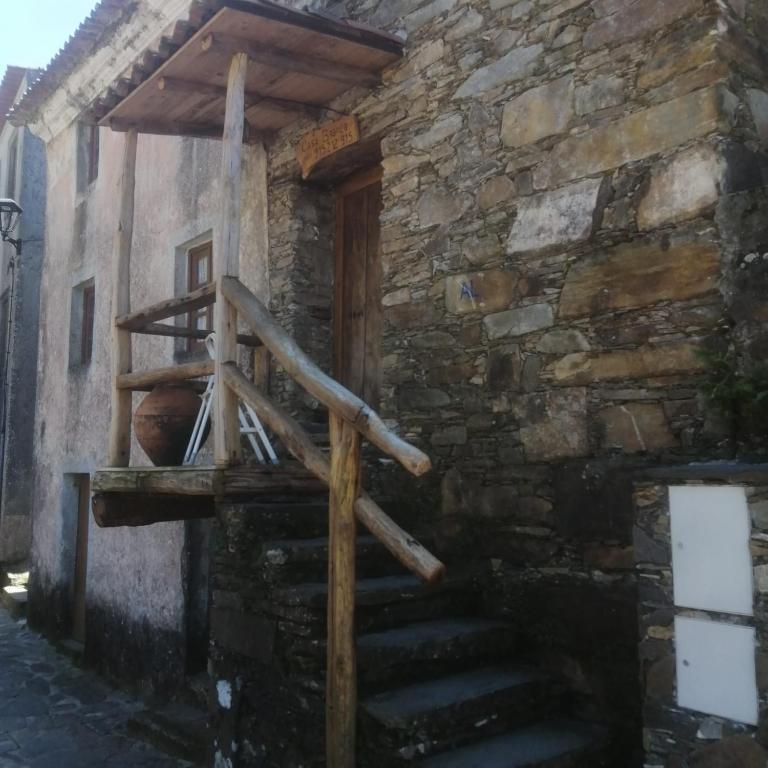 a stone building with a wooden staircase on it at Casa Branca in Lousã