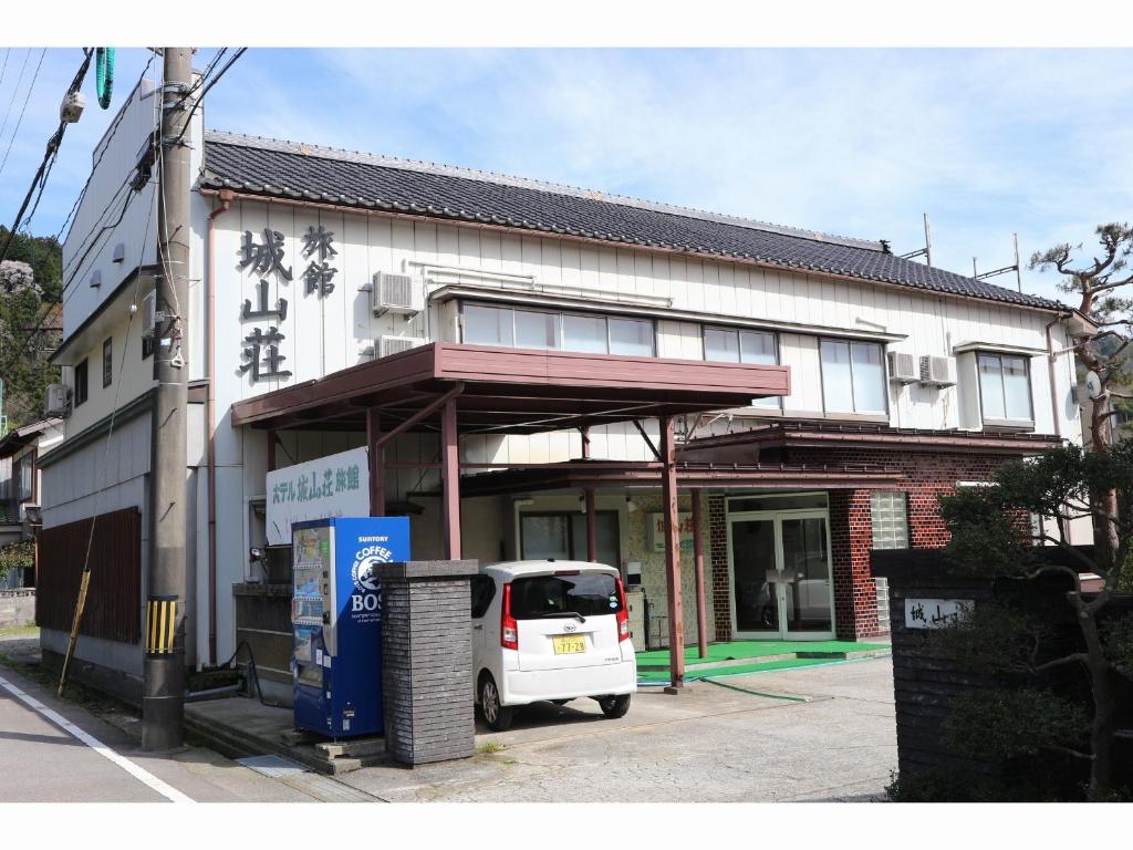 朝日的住宿－Shiroyamasou，停在大楼前的白色货车