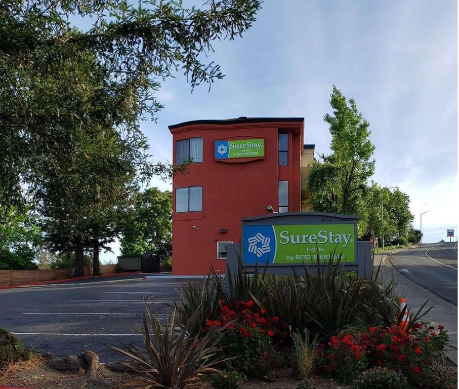 a red building with a sign in front of it at SureStay Hotel by Best Western Vallejo Napa Valley in Vallejo